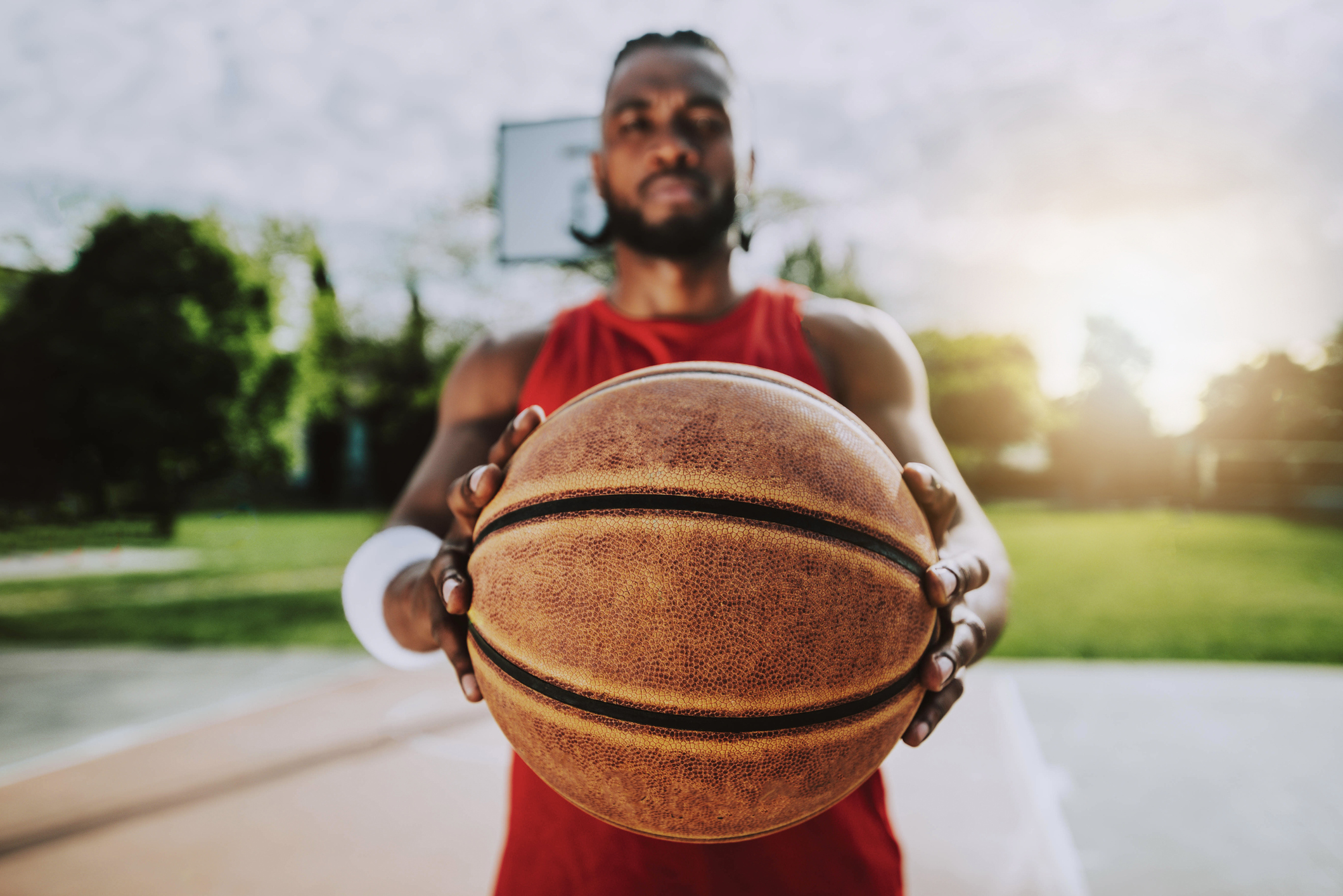 Holding balls. Баскетболист с мячом в руках фотосток. Человек держит мяч. Баскетболист держит мяч. Рука держит мяч.